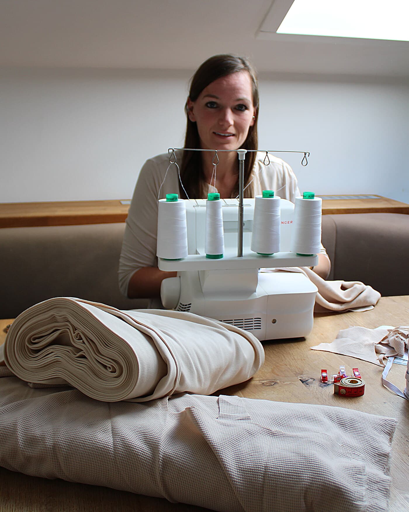 Chrissy an ihrer Overlock, sie schaut in die Kamera